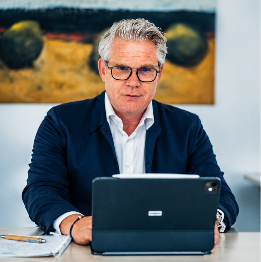 Carsten Stölting am Schreibtisch mit Tablet und Unterlagen